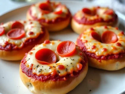 Air fryer pizza bagels with melted cheese and pepperoni on a white plate, golden crispy edges