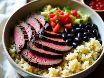 Chipotle steak bowl with sliced seared steak, cilantro lime rice, black beans, and salsa in a ceramic bowl